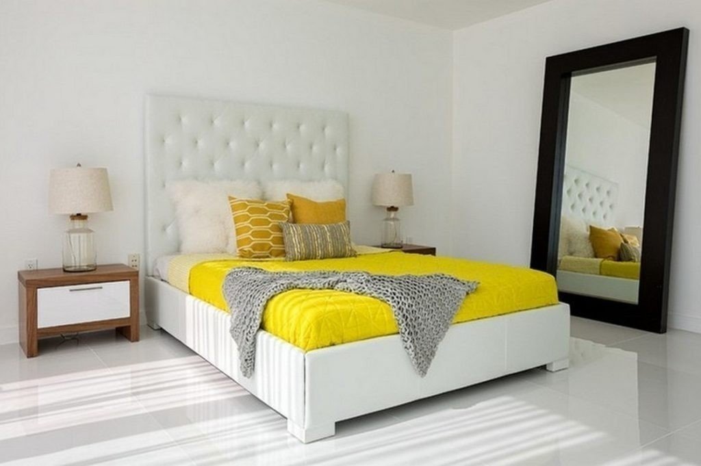 Желтая спальня с белой мягкой кроватью